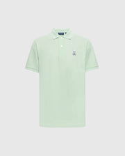 The Psycho Bunny MENS CLASSIC PIQUE POLO - B6K001F200 in light green is crafted from soft Pima cotton, featuring a classic collar, short sleeves, and two white buttons on the placket. It has a small embroidered bunny logo with crossed bones on the left chest against a plain white background.
