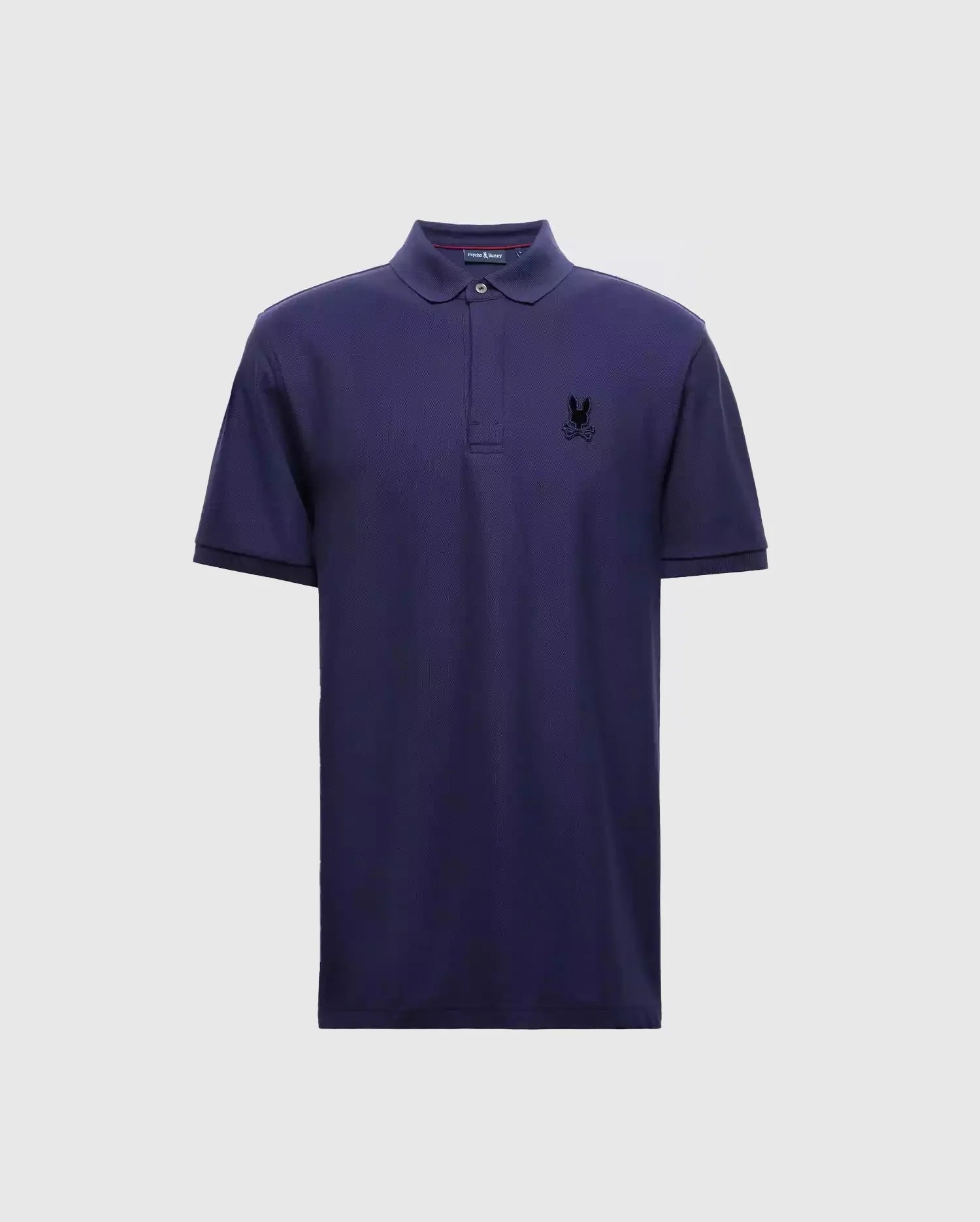 The Psycho Bunny MENS BRANSON PIQUE POLO - B6K108E200 is a premium quality navy blue polo for men, complete with short sleeves and a collar. It boasts a small black insignia on the left chest, providing an elegant contrast to the light gray background.
