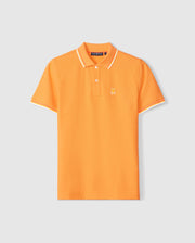A MENS GRANBURY PIQUE POLO - B6K400C200 from Psycho Bunny with white trim on the tipping collar and sleeve edges. Crafted from diamond-knit Pima cotton, it features a small embroidered bunny logo on the left chest area. The shirt is displayed against a plain light gray background.