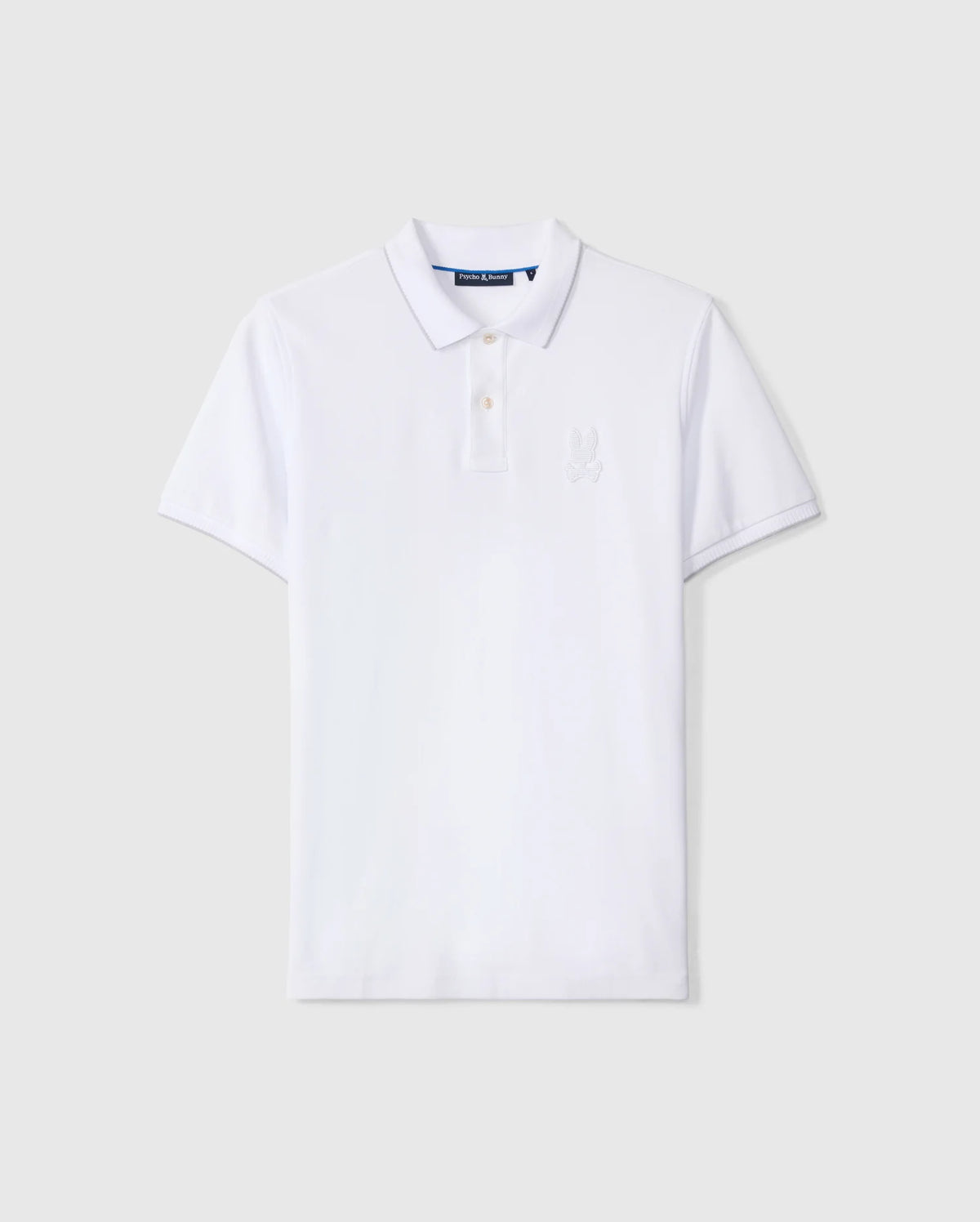 A classic white, short-sleeve Psycho Bunny Men's Kingston Pique Polo Shirt - B6K764D200 featuring a collar and a two-button placket, meticulously crafted from luxurious Pima cotton. A subtle embroidered Bunny patch adorns the left chest area against a light gray background.