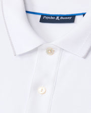Close-up of the white MENS KINGSTON PIQUE POLO SHIRT - B6K764D200 from Psycho Bunny, showcasing a small collar, two white buttons down the front, and a blue tag with the brand's name and logo on the inside of the collar. Crafted from soft Pima cotton, this shirt features an embroidered Bunny patch.