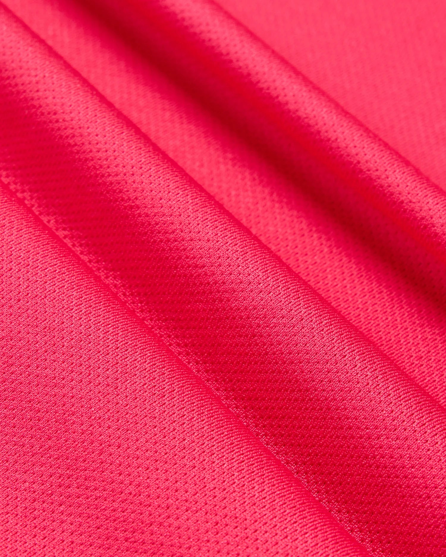 Close-up of vibrant pink satin fabric with a smooth and slightly textured surface, showcasing the material's glossy finish and delicate folds, reminiscent of the Psycho Bunny MENS BELLEVUE SPORT POLO SHIRT - B6K905D200 in its attention to detail.
