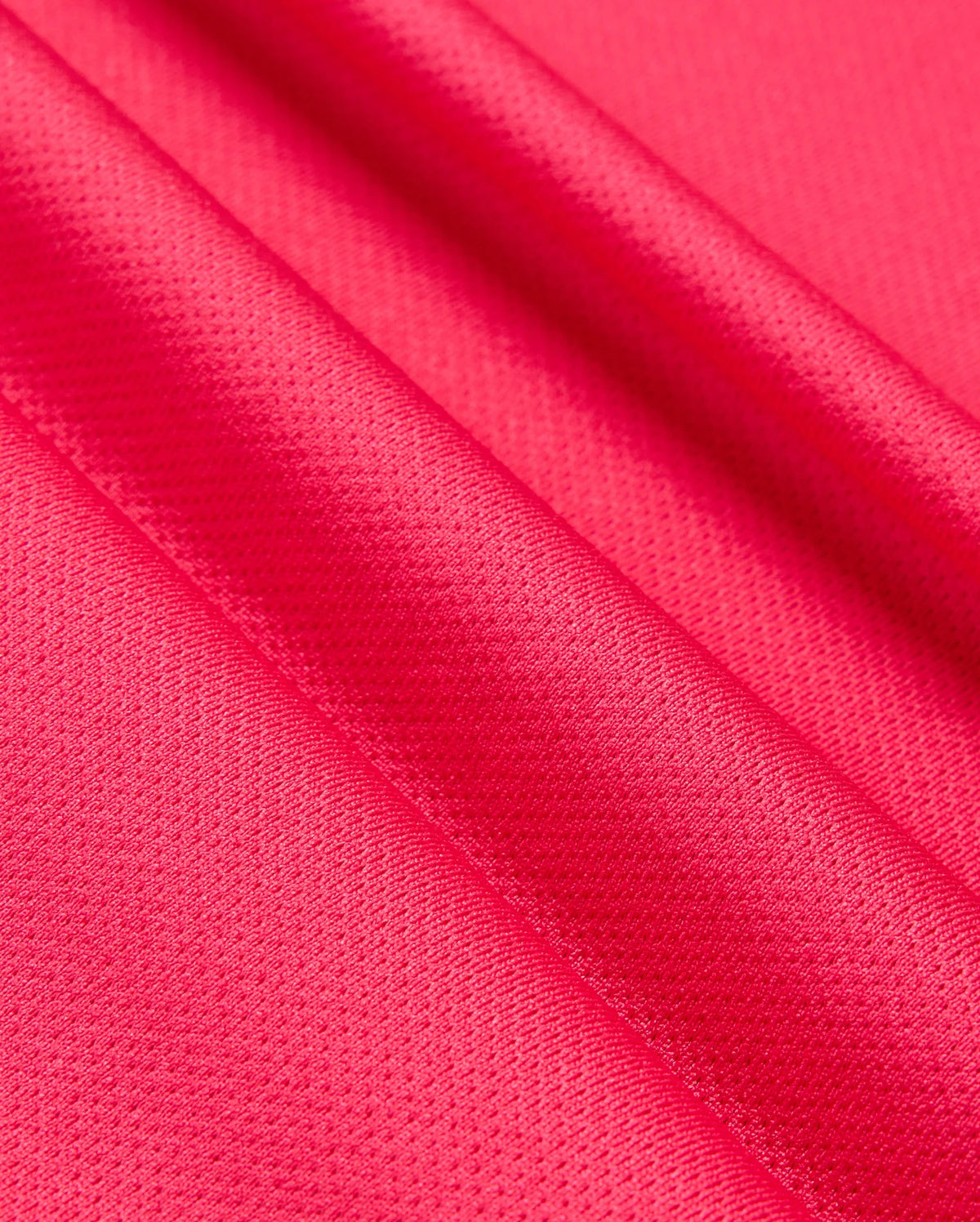Close-up of vibrant pink satin fabric with a smooth and slightly textured surface, showcasing the material's glossy finish and delicate folds, reminiscent of the Psycho Bunny MENS BELLEVUE SPORT POLO SHIRT - B6K905D200 in its attention to detail.