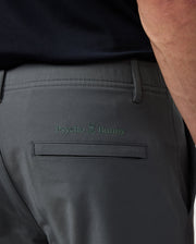 Close-up of the back pocket of Psycho Bunny men's Madison commuter pant showing the "psycho bunny" logo embroidered above the pocket.