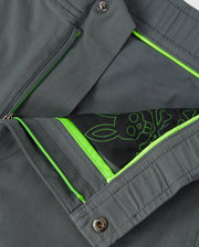 Close-up of a Psych Bunny MENS MADISON COMMUTER PANT - B6P395Z1WB showing interior detail with a neon green zipper and lining, and a decorative sketch of flower and leaves in white on a stretch woven material background.