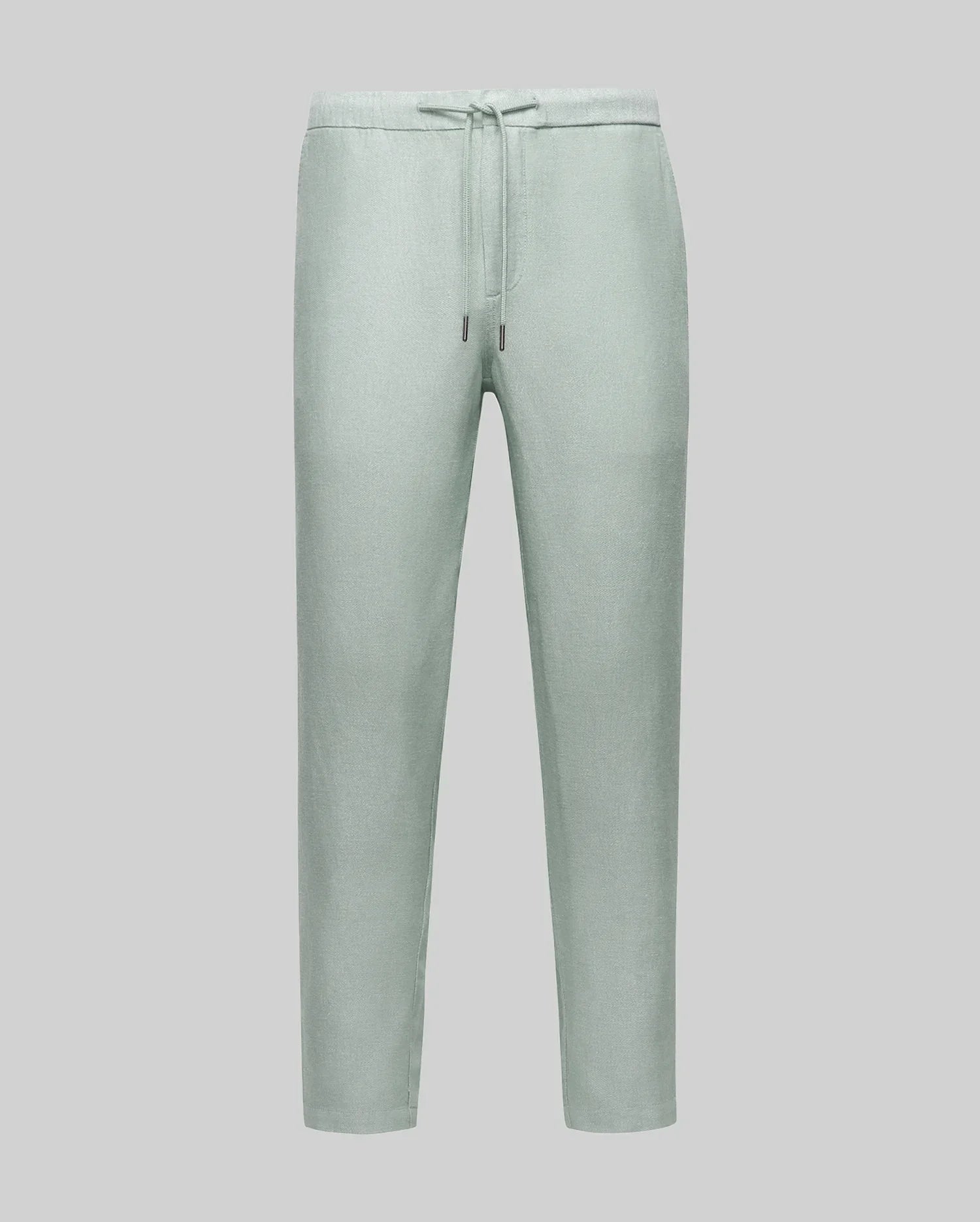 Psycho Bunny light green trousers with a drawstring waist, showcasing a relaxed fit and subtle texture, embodying refined streetwear style.