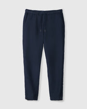 The MENS FATE LINEN DRAWSTRING PANT - B6P471C200 by Psycho Bunny are navy blue jogger pants featuring an elastic waistband and a drawstring. These summer trousers offer side pockets, a relaxed fit, and taper slightly at the ankles. Made from lightweight fabric, they ensure ultimate comfort.