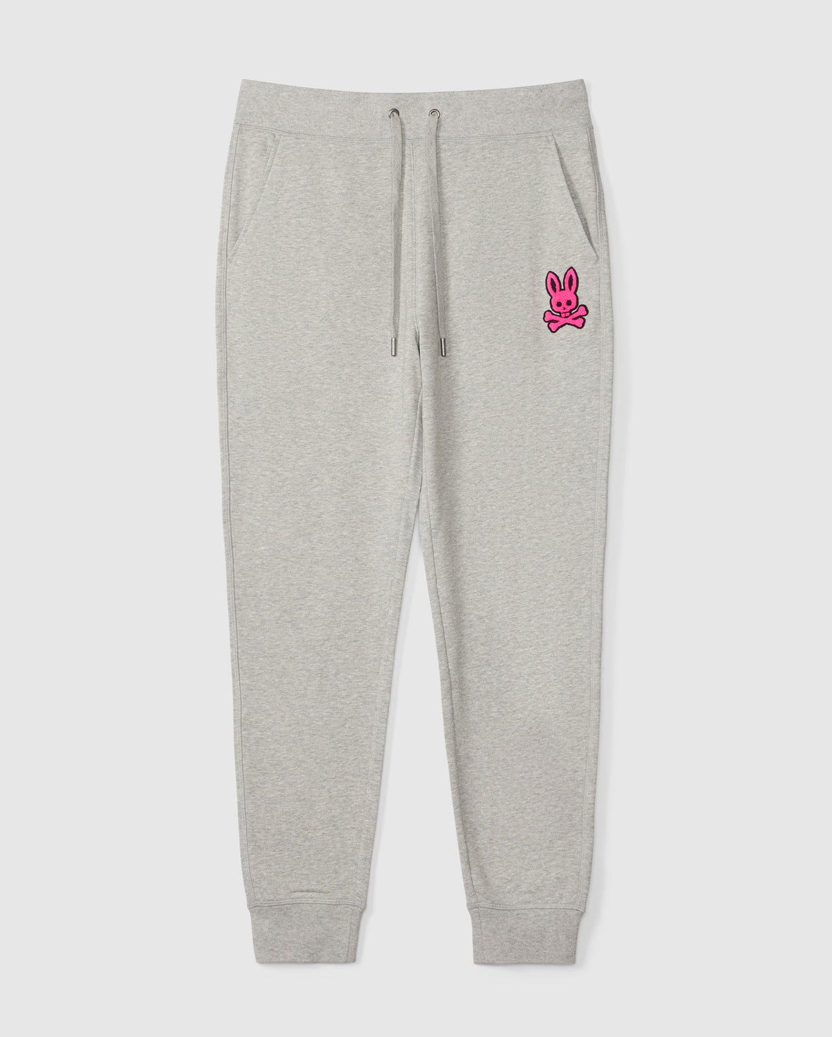 The SCOTT CHENILLE PATCH SWEATPANT by Psycho Bunny, product code B6P856D200, features a pink bunny and crossbones design on the left upper leg. It includes an elastic waistband with drawstrings and ankle cuffs.