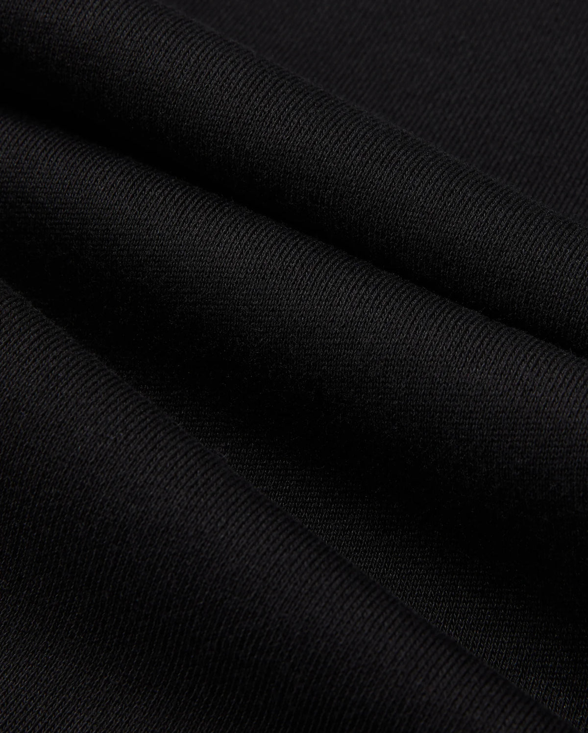 A close-up of the black fabric reveals a fine, smooth texture and gentle folds, showcasing its intricate weave pattern reminiscent of the Psycho Bunny Mens Pacific Chenille Jogger - B6P972D200.