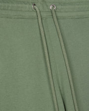 Close-up of a green fabric with drawstrings, featuring silver eyelets. The smooth texture resembles that of the MENS PACIFIC CHENILLE JOGGER - B6P972D200 by Psycho Bunny, with strings neatly tied through the eyelets at the top, adding a touch of elegance to this casual bottom.