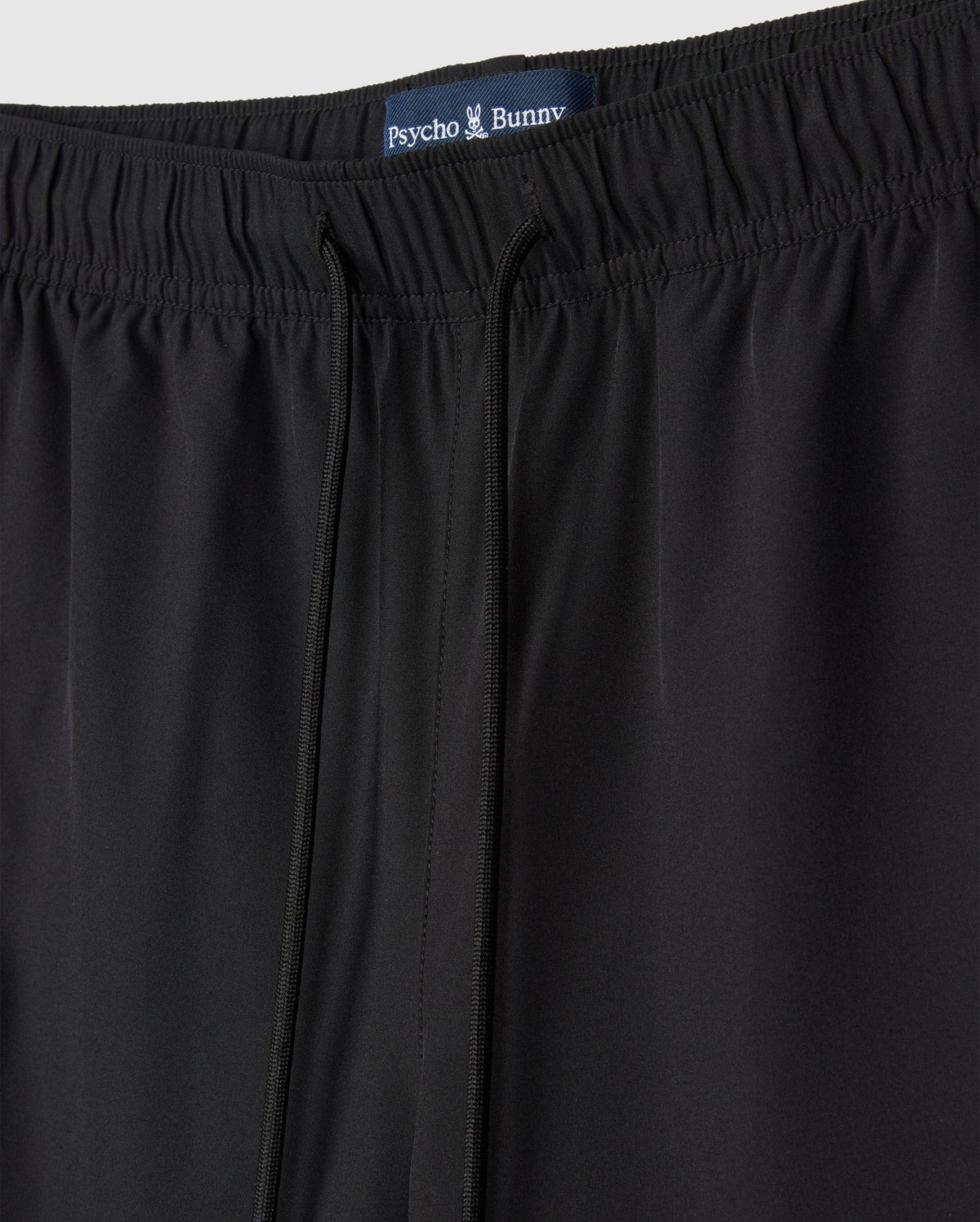 A close-up of a pair of black MENS SONTERRA STRIPE SPORT SHORT - B6R464C200 by Psycho Bunny made from quick-drying, breathable fabric.