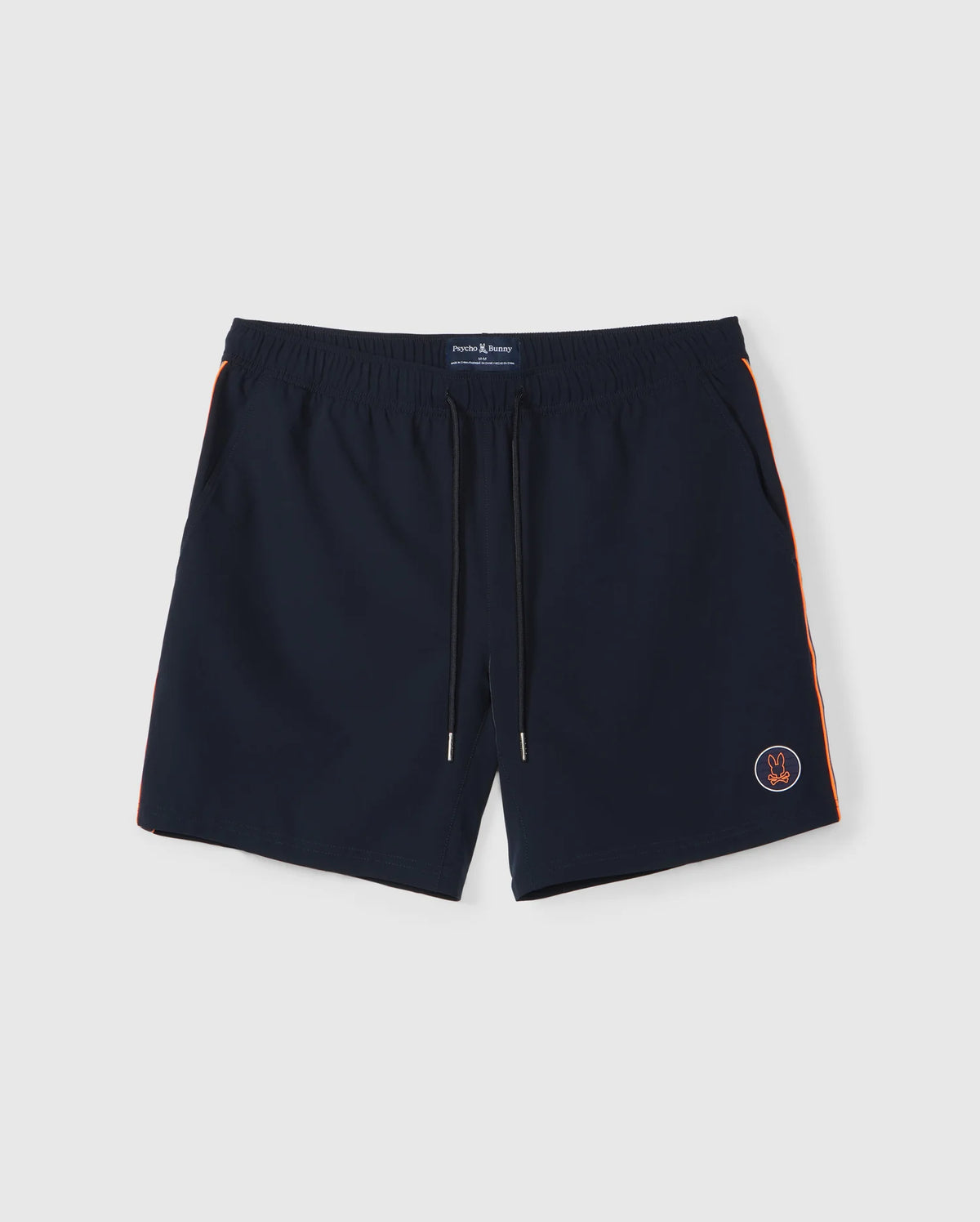 A pair of dark blue Psycho Bunny MENS SONTERRA STRIPE SPORT SHORT - B6R464C200 with an elastic waistband and drawstring, crafted from quick-drying stretch fabric. The shorts feature orange stripes along the sides and a small embroidered emblem near the bottom left hem, set against a plain white surface.