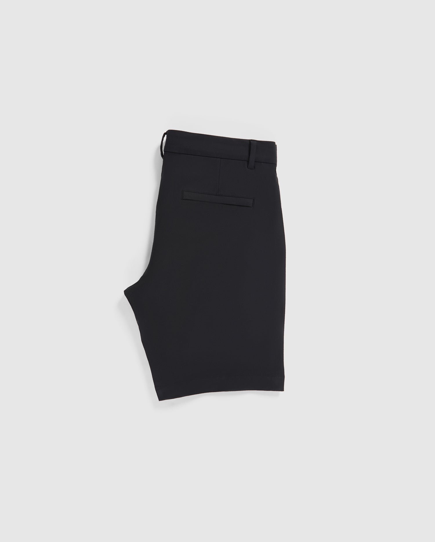 A pair of neatly folded Psycho Bunny MENS GABLE REGULAR FIT SPORT SHORT - B6R761ARCN made from a smooth, durable stretch cotton-nylon fabric is displayed on a plain white background. The black shorts feature belt loops, a hidden zip pocket, and a single welt pocket on the back.