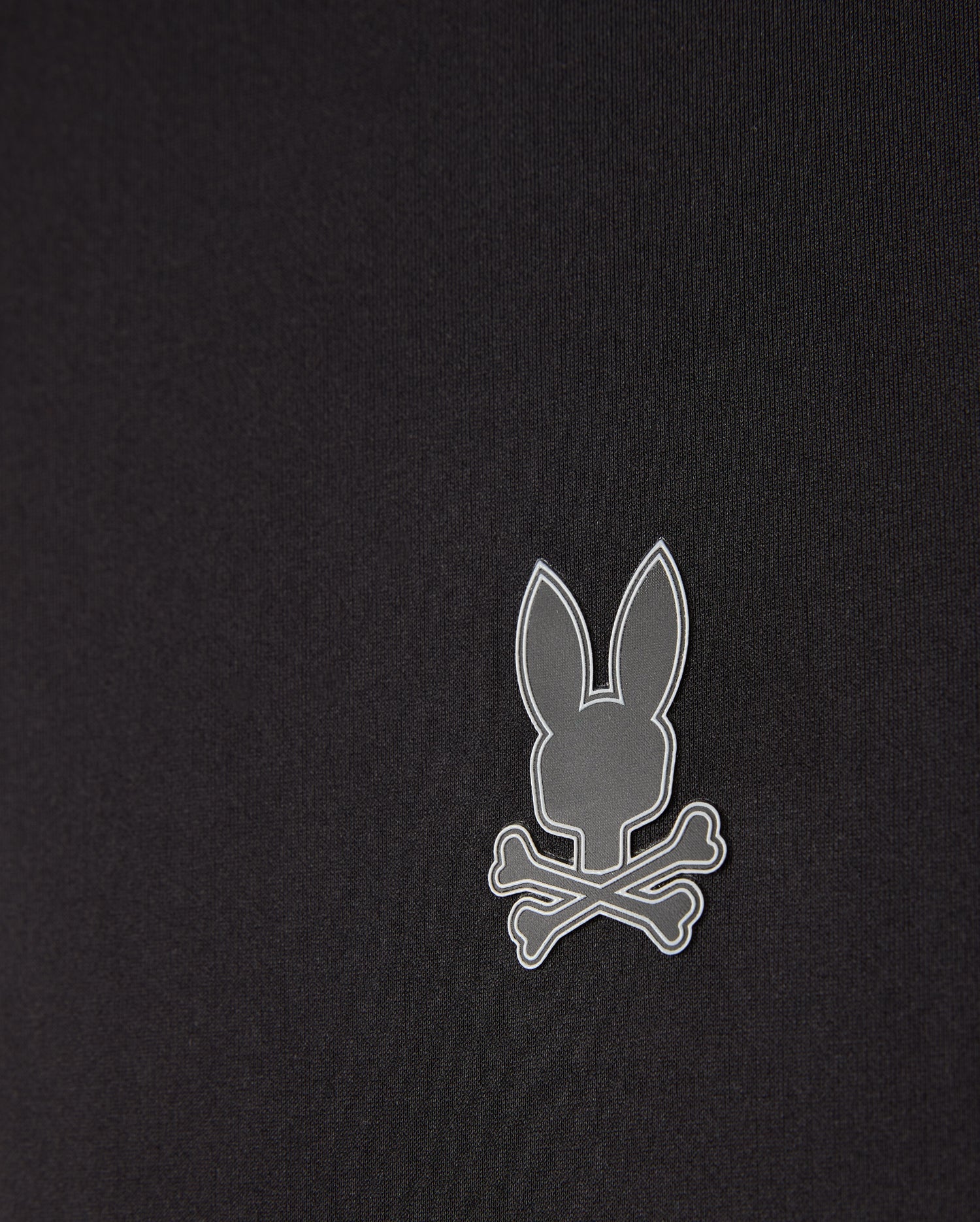 The men's Laurier 1/4 zip hoodie by Psycho Bunny in black features an off-center, small gray emblem of a bunny head above crossed bones. Its minimalist and modern design complements any athleisure look perfectly.