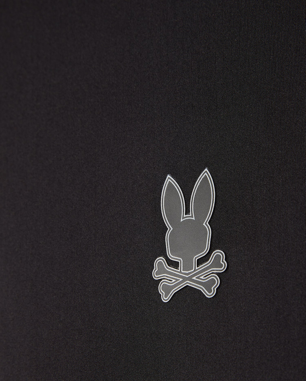 The men's Laurier 1/4 zip hoodie by Psycho Bunny in black features an off-center, small gray emblem of a bunny head above crossed bones. Its minimalist and modern design complements any athleisure look perfectly.