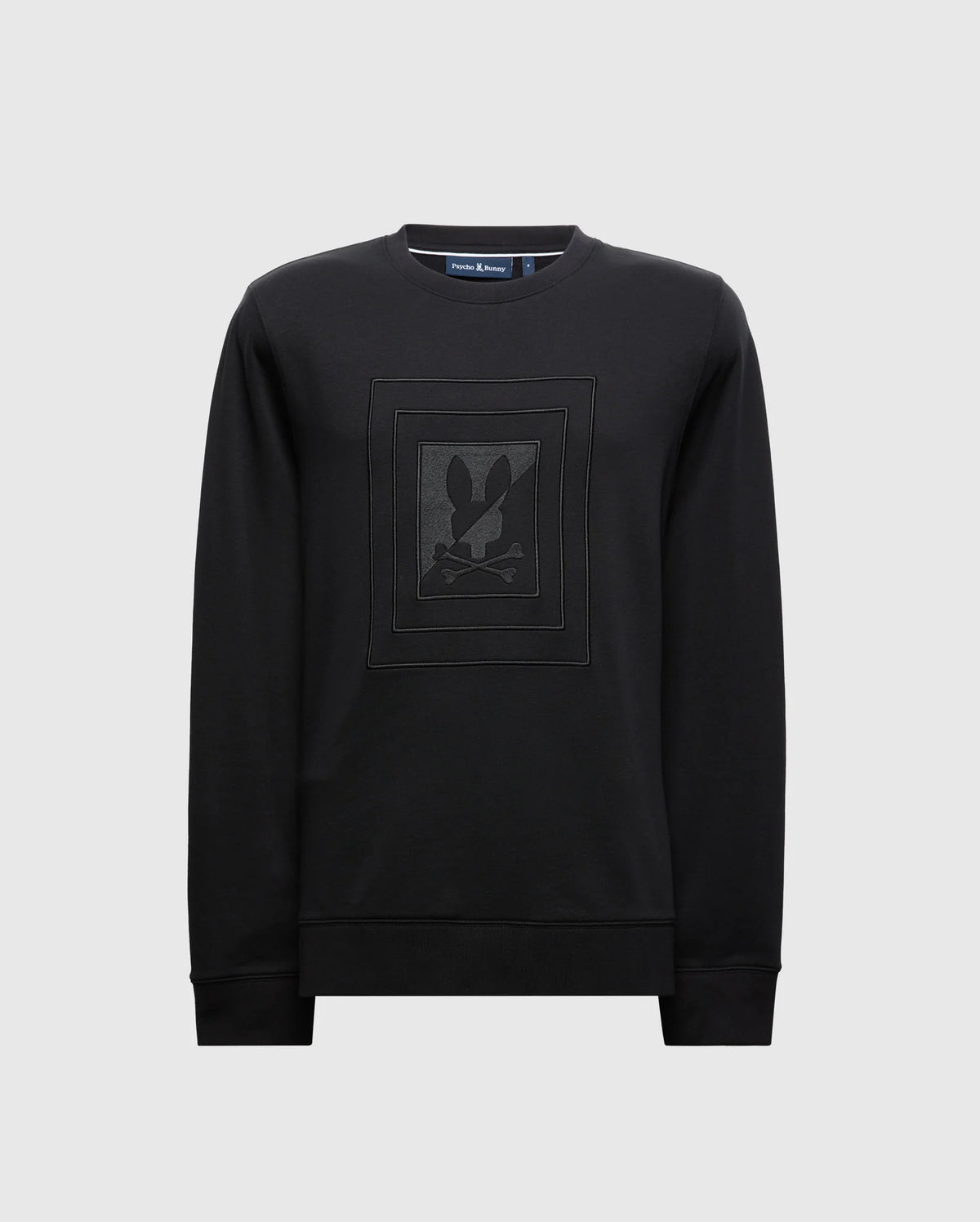 The MENS OAK CITY CREW NECK - B6S274E200 by Psycho Bunny is a premium black sweatshirt with a lightweight crew neck and long sleeves. It features subtle raised embroidery of a stylized rabbit and crossbones design on the chest, set against a plain light gray background.