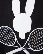 A black background showcases a white minimalist rabbit head graphic above two crisscrossed tennis rackets, creating a tennis-inspired aesthetic. This design perfectly embodies the sporty sophistication of the MENS COURTSIDE SWEATSHIRT - B6S688C200 by Psycho Bunny, crafted for style and comfort from breathable cotton-blend fabric.