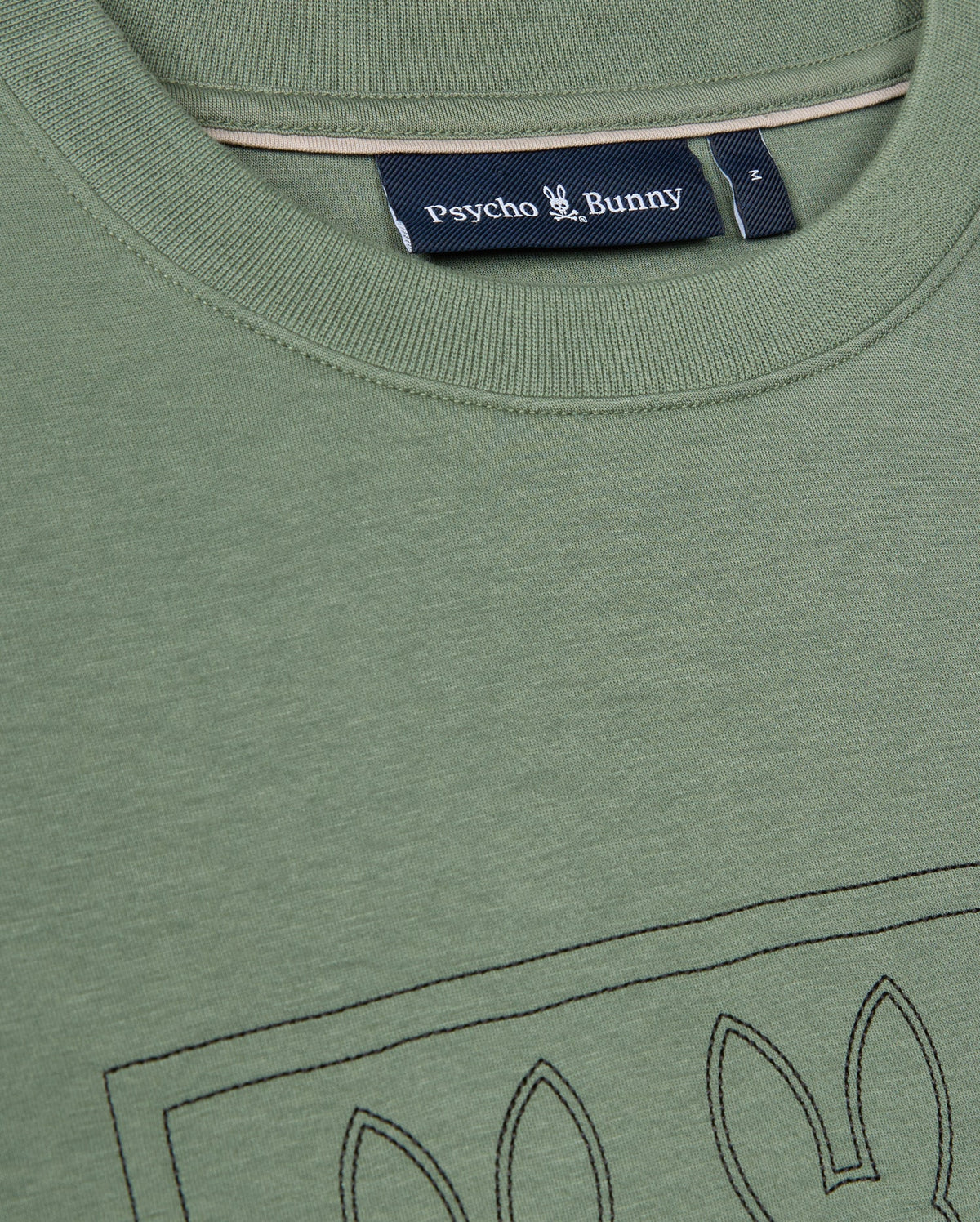 A close-up view of the green Mens Tacoma Sweatshirt by Psycho Bunny highlights its luxurious comfort and stitched bunny ear outline on the front, with the label prominently displayed beneath the collar. The premium stretch fabric guarantees a perfect fit while maintaining a lightweight feel.