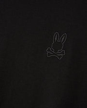 Introducing the MENS ALBERTON LONG SLEEVE TEE - B6T867D200 by Psycho Bunny, featuring a detailed embroidered design of a bunny with crossed bones beneath. This black fabric tee is crafted from premium Pima cotton, delivering both a stylish appearance and luxurious comfort.