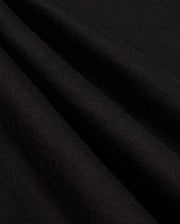 Close-up of the black Pima cotton fabric folds from the Psycho Bunny MENS ALBERTON LONG SLEEVE TEE - B6T867D200, showcasing a smooth, soft texture and fine weave. The wrinkles create subtle shadows, highlighting the material's flexibility and quality—truly a fashion masterpiece.