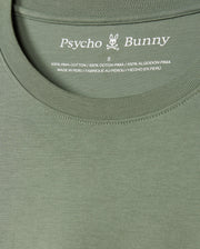 Close-up of the MENS ALBERTON LONG SLEEVE TEE - B6T867D200 in vibrant green, prominently displaying the Psycho Bunny label along with a small bunny logo. The label details the size and confirms that it is made from 100% Pima cotton, crafted in Peru—a true fashion masterpiece.