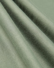 A detailed view of the Mens Alberton Long Sleeve Tee by Psycho Bunny, crafted from green Pima cotton that boasts a smooth texture and soft sheen, beautifully draped in gentle folds. The tee's weave and interaction with natural light produce delicate variations in color and shadow, elevating it to a true fashion masterpiece.