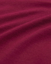 Close-up image of a rich, burgundy-colored fabric with visible texture and gentle folds, highlighting its soft and smooth surface—perfect for a breathable and lightweight men's crewneck tee made from luxurious Pima cotton: the MENS CLASSIC CREW NECK TEE - B6U014Z1PC by Psycho Bunny.