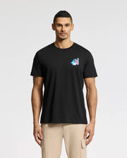 A man wearing a Psycho Bunny MENS TORONTO TEE - B6U383F200 made of Pima cotton, featuring a colorful mountain graphic on the left chest, pairs it perfectly with light tan pants against a white background.