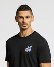 A man with short hair wears the Psycho Bunny MENS TORONTO TEE, a black shirt made from soft Pima cotton. It features a small, colorful bunny graphic and text on the upper left. The plain white background accentuates its striking yet subtle design.