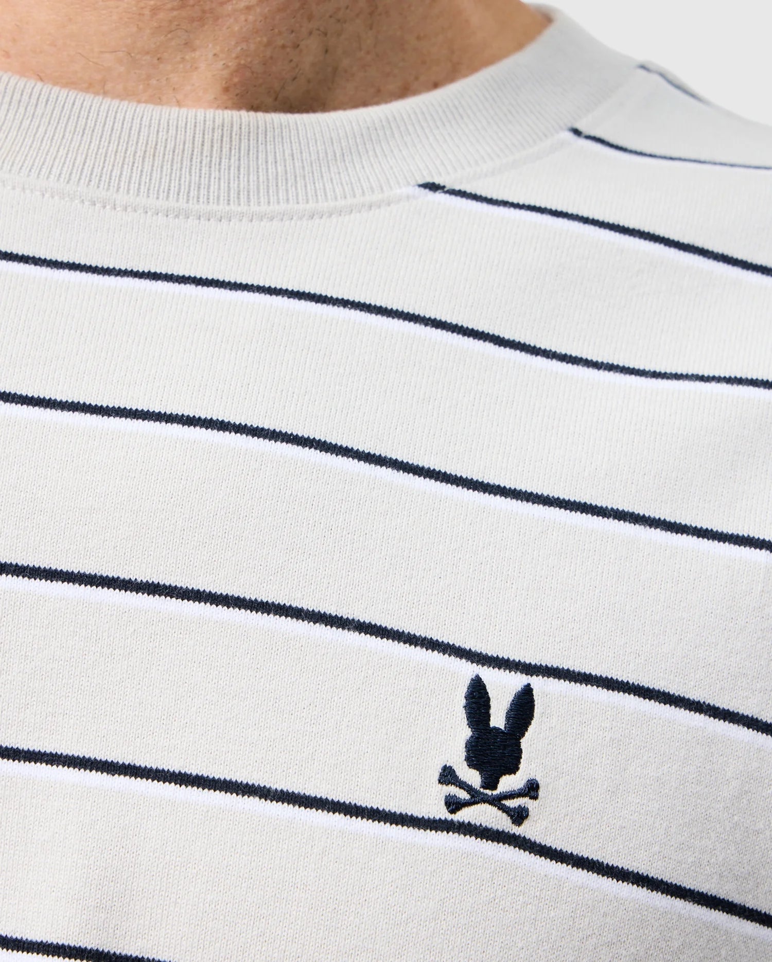 A close up of the mens pima cotton alton stripe heavy weight tee featuring black stripes and a black brand logo