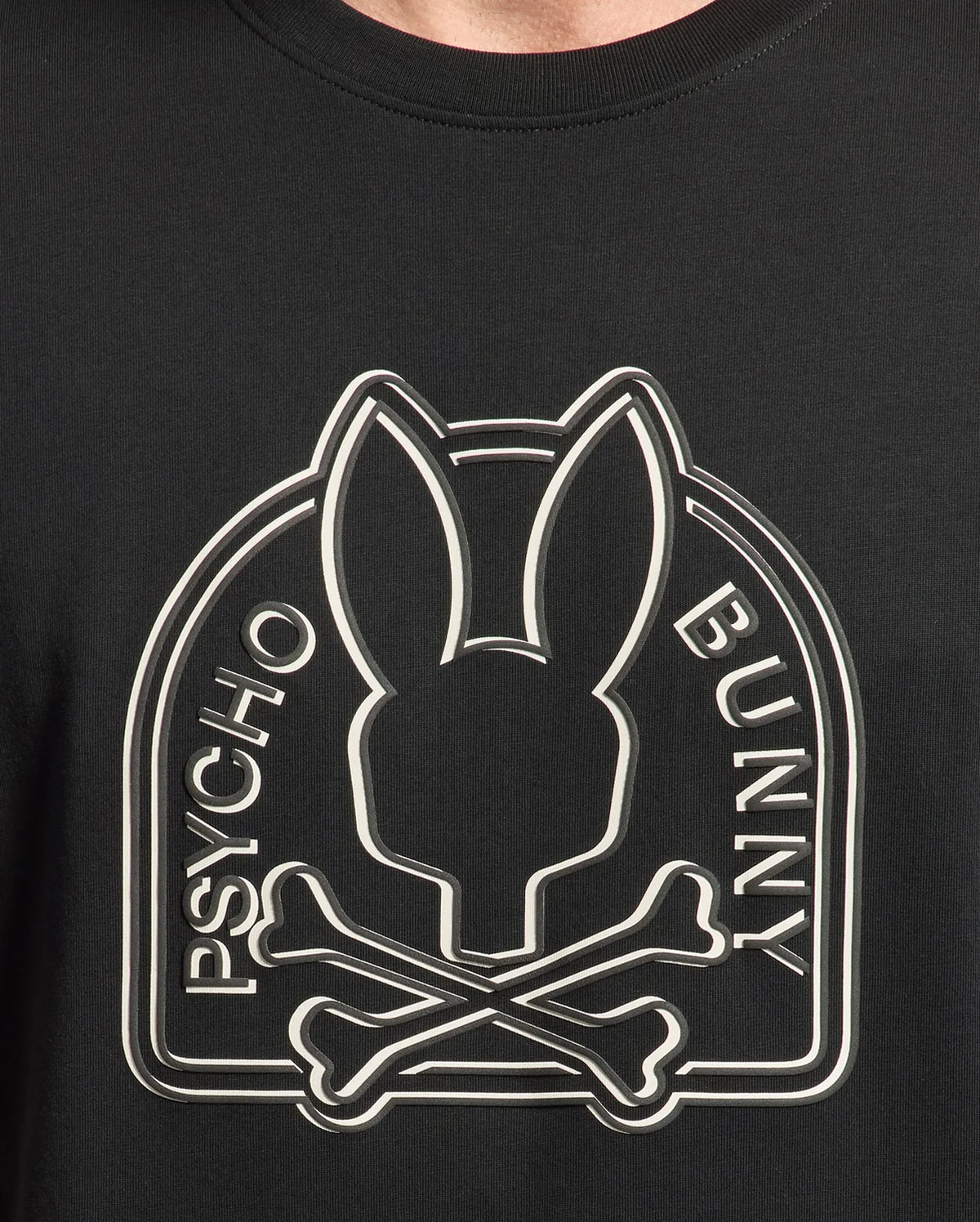 A close-up of the black Psycho Bunny mens Melbourne graphic tee made from Peruvian Pima knit, showcases a stylized bunny head above crossed bones with "Psycho Bunny" on either side.