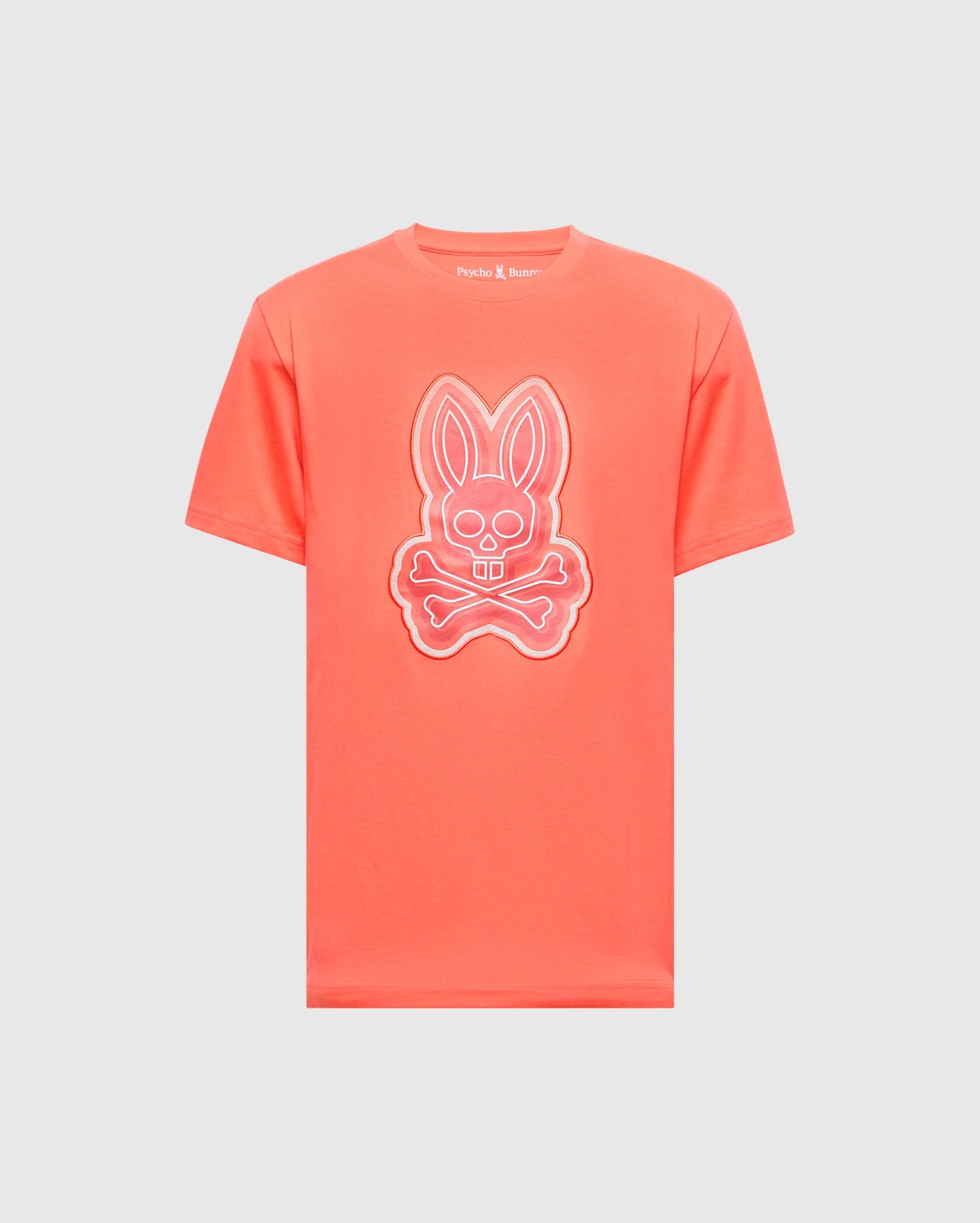 The MENS SYDNEY GRAPHIC TEE - B6U508F200 by Psycho Bunny is a coral-colored, soft Pima cotton T-shirt featuring a glow-in-the-dark bunny with crossed bones graphic on the front.