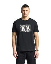 A young man wears a Psycho Bunny MENS GOLD COAST GRAPHIC TEE, featuring Pima cotton and two abstract bunny figures with "Psycho Bunny" on the front, reflecting premium craftsmanship against a plain white background.