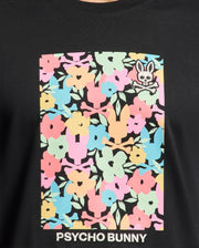 Experience all-day comfort in the Mens Lemmon Graphic Tee by Psycho Bunny, crafted from soft black Pima cotton adorned with colorful pink, blue, yellow, and green floral patterns. A small Bunny graphic with crossbones sits top right, and "Psycho Bunny" is elegantly printed at the bottom.