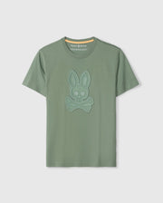 The Psycho Bunny MENS MALTON GRAPHIC TEE - B6U795D200 is a green short-sleeve shirt made from luxurious Pima cotton, featuring a blue embossed design of a bunny skull and crossbones on the front. This Peruvian-crafted tee boasts a round neckline with a yellow inner neck lining.