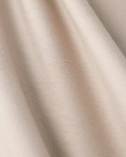 Close-up of the MENS CAMPO POCKET TEE - B6U801D200 by Psycho Bunny, showcasing beige fabric with a smooth texture and gentle folds. This lightweight material, similar to finely woven pima cotton, offers a subtle sheen with soft shadows and highlights.