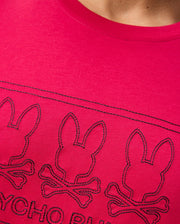 Close-up of the MENS TACOMA GRAPHIC TEE - B6U909D200, crafted from Pima cotton, featuring intricately stitched black outlines of three bunny heads above crossbones. The brand name "Psycho Bunny" is elegantly embroidered at the bottom in black thread.