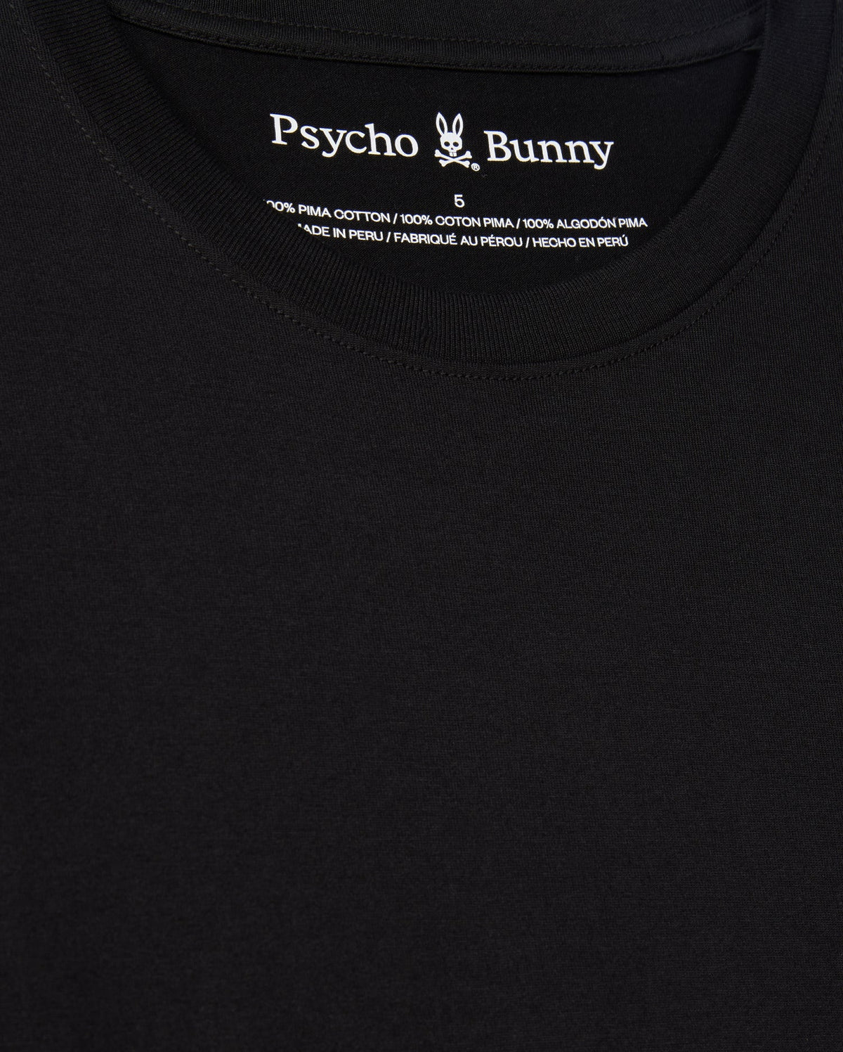 Close-up of a black t-shirt titled "MENS JAMES PREMIUM CREW NECK TEE - B6U952D200" by Psycho Bunny, showcasing the logo and text on the inside collar. Crafted from Premium Pima cotton, this shirt exhibits meticulous embroidery with a stylized bunny graphic. The fabric appears smooth, exemplifying excellence in Peruvian craftsmanship.