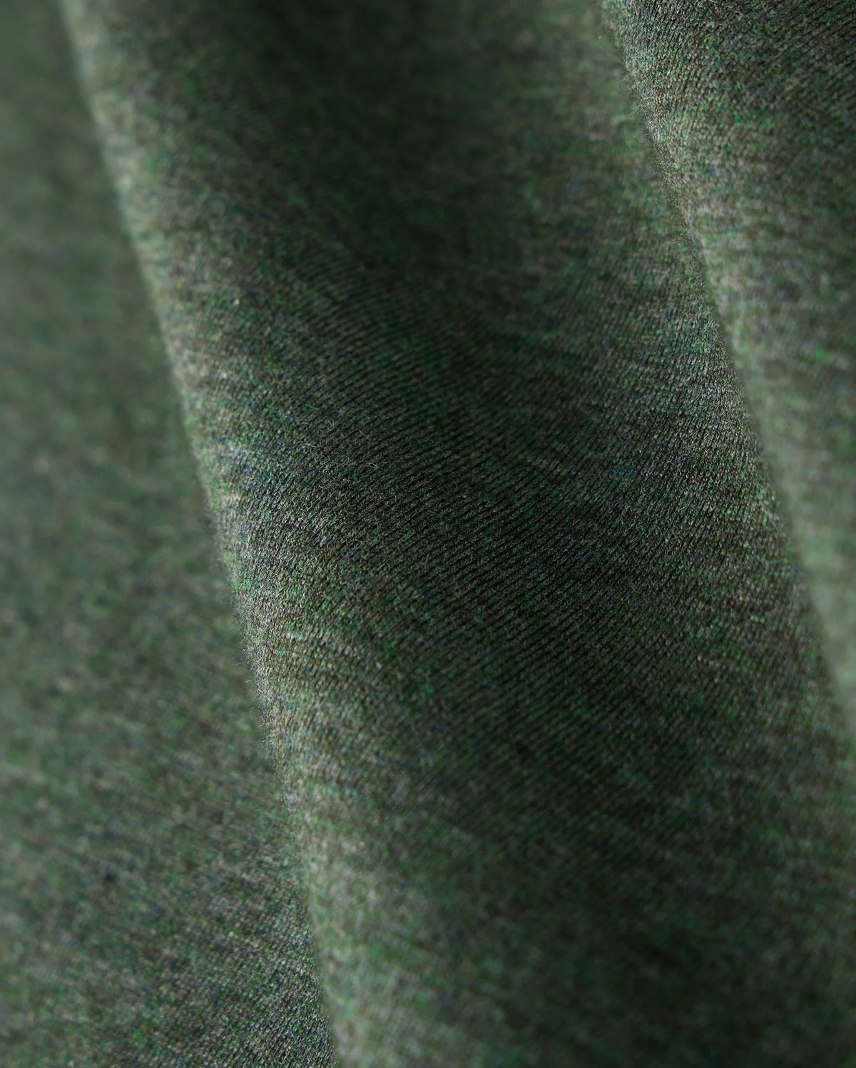 Close-up of a Psycho Bunny MENS JAMES PREMIUM CREW NECK TEE - B6U952D200, crafted from premium Pima cotton in green. The fabric showcases a soft texture with a subtle diagonal pattern, appearing smooth and gently draped. It highlights the tonal outline bunny embroidered into the weave along with its natural folds.