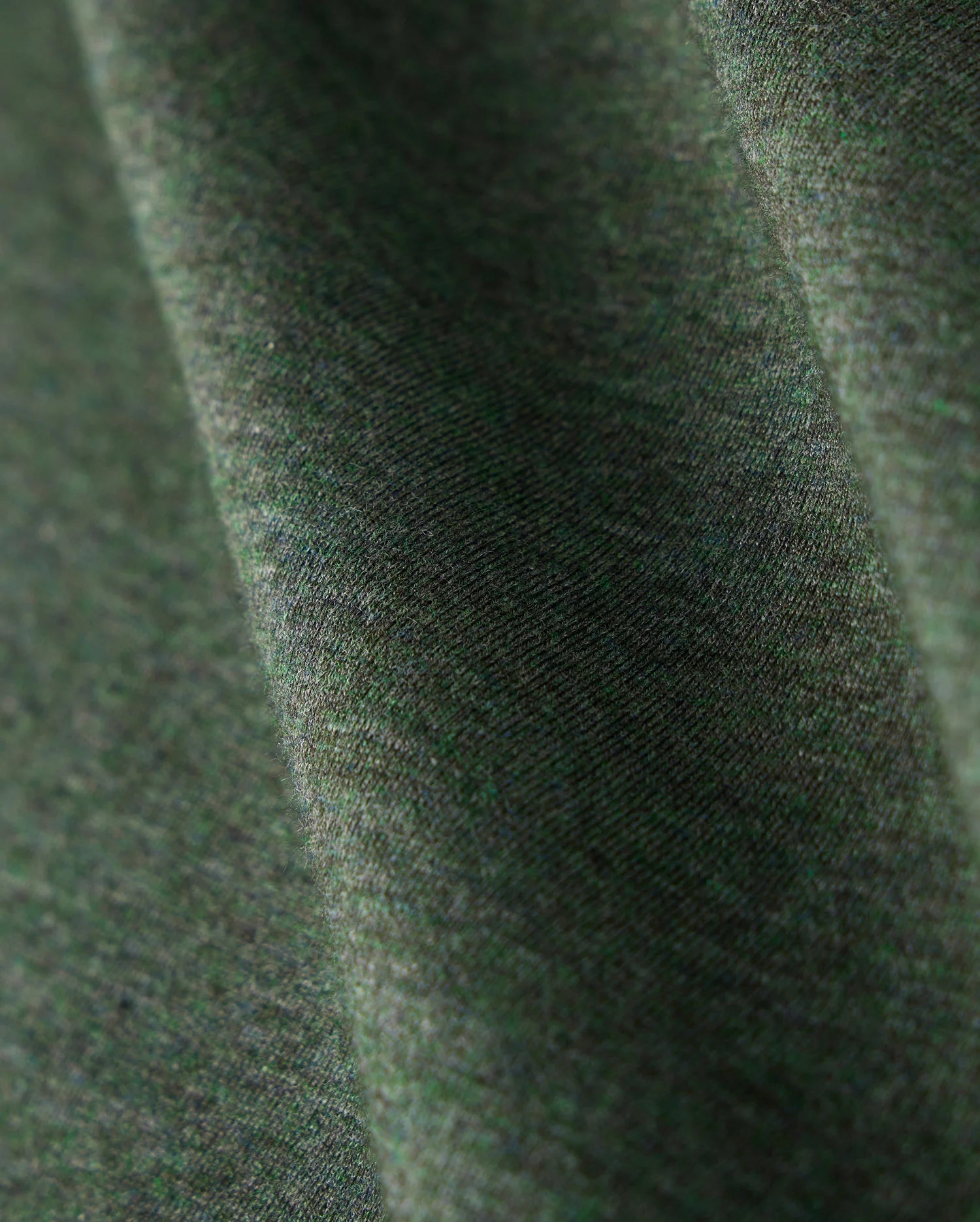Close-up of a Psycho Bunny MENS JAMES PREMIUM CREW NECK TEE - B6U952D200, crafted from premium Pima cotton in green. The fabric showcases a soft texture with a subtle diagonal pattern, appearing smooth and gently draped. It highlights the tonal outline bunny embroidered into the weave along with its natural folds.