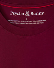 Close-up of the label on the maroon MENS MALTON FASHION TEE - B6U966D200 by Psycho Bunny, displaying size 5. The chic T-shirt label emphasizes "100% Pima Cotton" and notes that the shirt is "Made in Peru" in English, French, and Spanish.