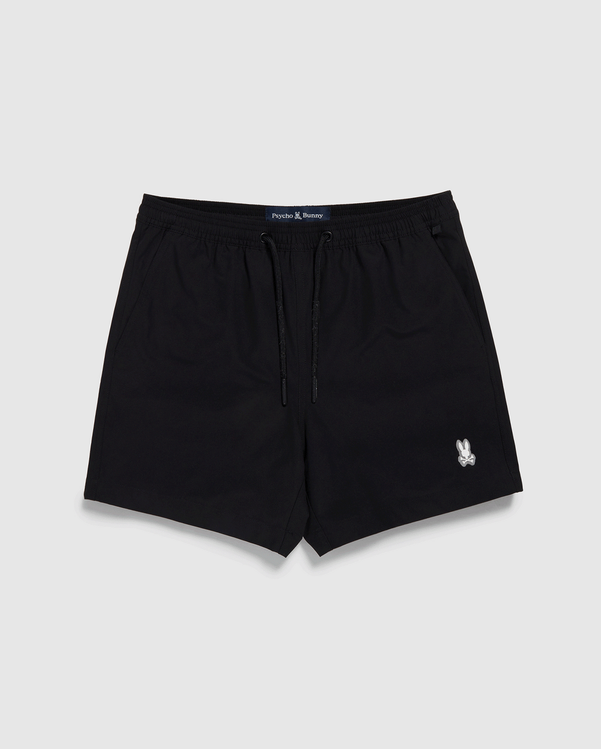Black Psycho Bunny swim trunks with a drawstring and a small white logo on the left leg, displayed against a white backdrop. The label "Jack & Jones" is visible on the waistband.