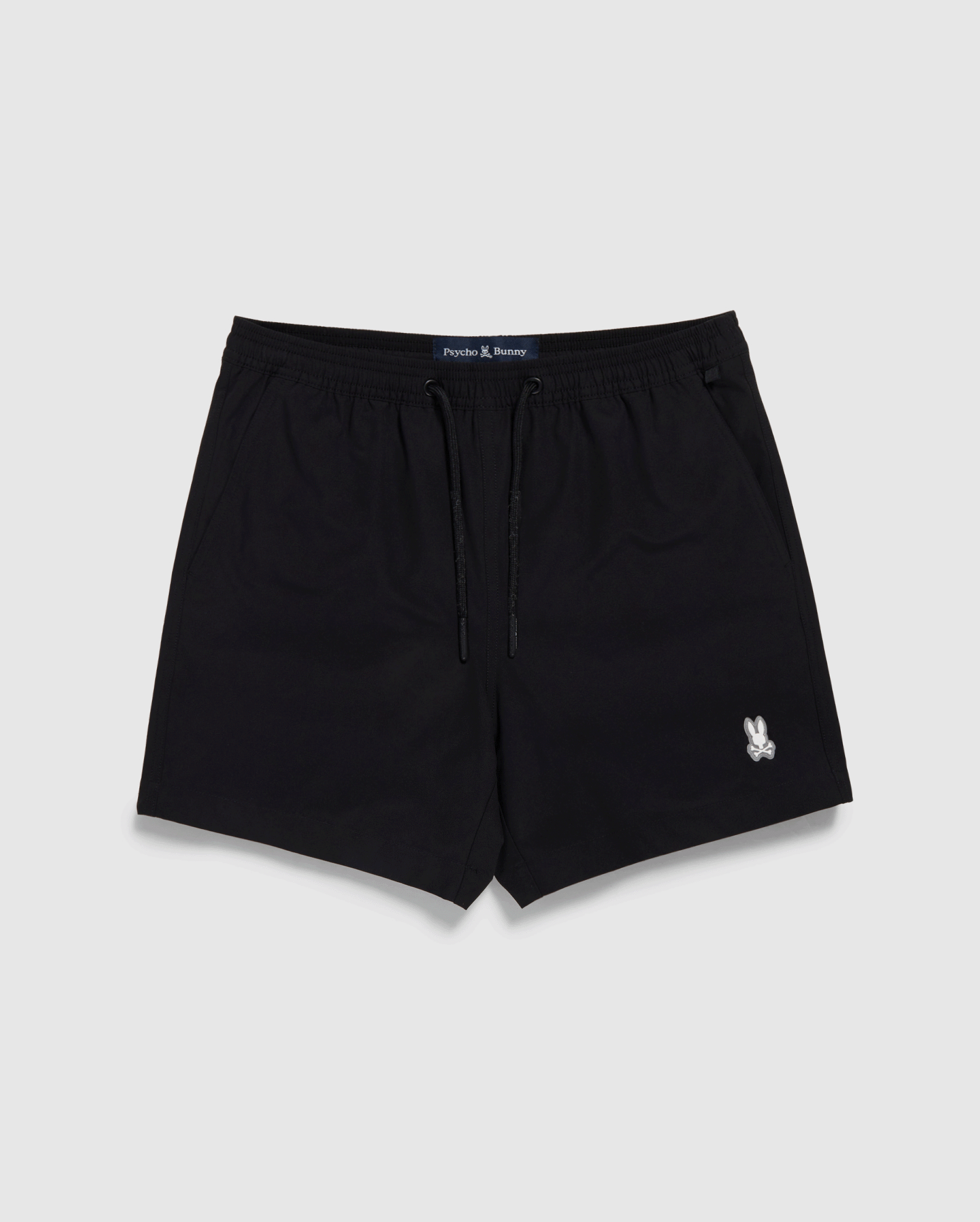 Black Psycho Bunny swim trunks with a drawstring and a small white logo on the left leg, displayed against a white backdrop. The label "Jack & Jones" is visible on the waistband.