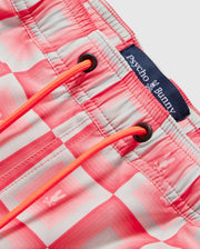 Close-up of pink and white checkered Psycho Bunny MENS UTICA SWIM TRUNK - B6W399B2SW with orange drawstrings and a label displaying the brand "Psycho Bunny.