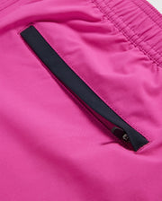 Close-up image of a bright pink fabric on quick-drying MENS PARKER HYDROCHROMIC SWIM TRUNK - B6W646C200 by Psycho Bunny, featuring a black zippered pocket. The pocket zipper is partially visible against the vibrant pink background. The fabric appears smooth and slightly shiny, suggesting a likely synthetic material.