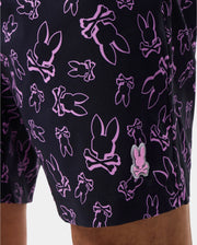 Close up of the mens rendom print swim trunk featuring a pink psycho bunny batch and a purple psycho bunny logo pattern
