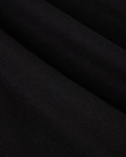 A close-up of black Pima cotton fabric drapes gracefully, showcasing soft, diagonal folds and shadows on this Psycho Bunny BIG AND TALL MALTON PIQUE POLO SHIRT - B9K950D200.