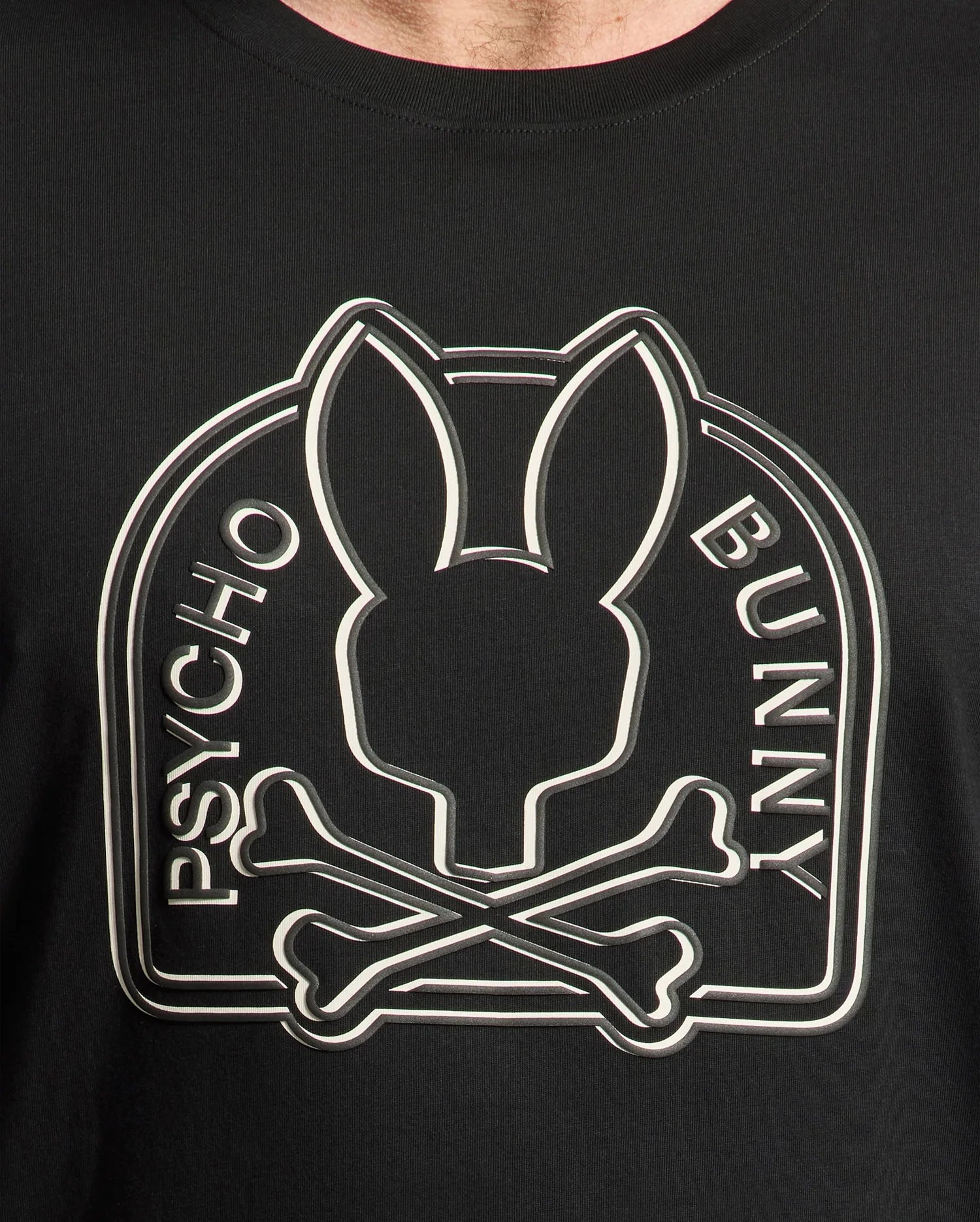 The Men's Big and Tall Melbourne Graphic Tee B9U410F200 by Psycho Bunny features a black Peruvian Pima cotton shirt with a stylized bunny silhouette above crossed bones, encircled by "Psycho Bunny," offering stylish, eco-friendly comfort.