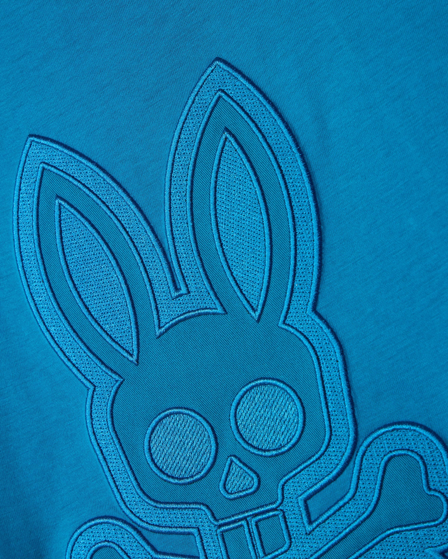 The BIG AND TALL MALTON GRAPHIC TEE - B9U795D200 by Psycho Bunny features a detailed blue embroidered design on premium Pima cotton, showcasing a rabbit with large ears and round eyes and a skull and crossbones motif against a matching blue background, highlighting exquisite Peruvian craftsmanship.