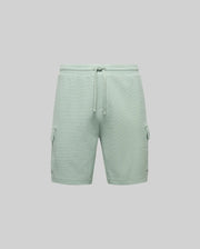 Psycho Bunny MENS RON WAFFLE CARGO SHORT (MB0900012) in light green features an elastic waistband, drawstring, large side flap pockets, and subtle embroidered logos, shown against a plain gray background.